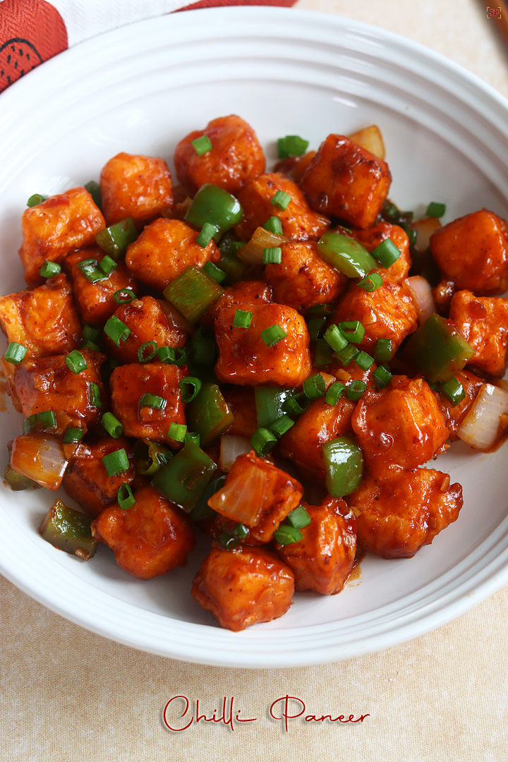 chilli paneer placed in a rimmed white bowl