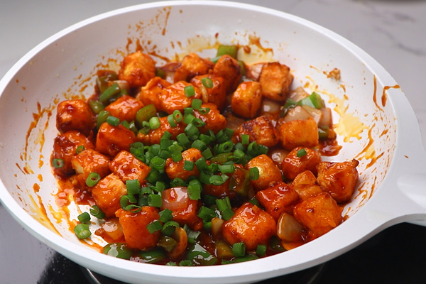 paneer is tossed well and spring onion is added