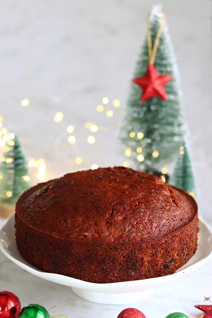 plum cake on a plate with christmas tree on the background