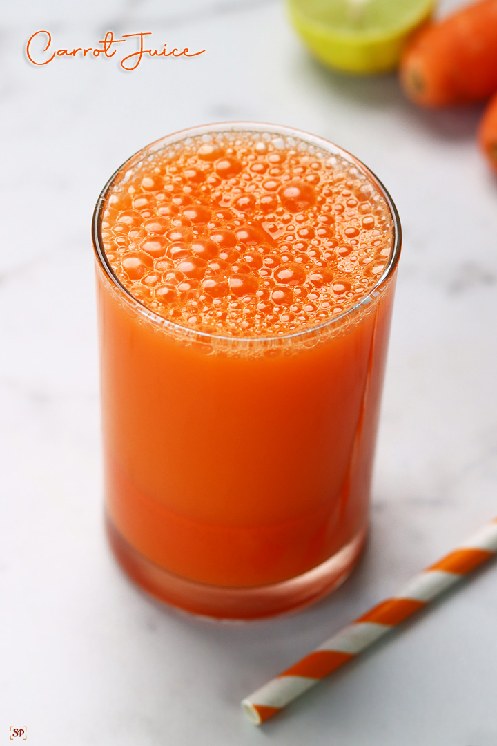 Carrot Juice served in a glass with a straw on the side