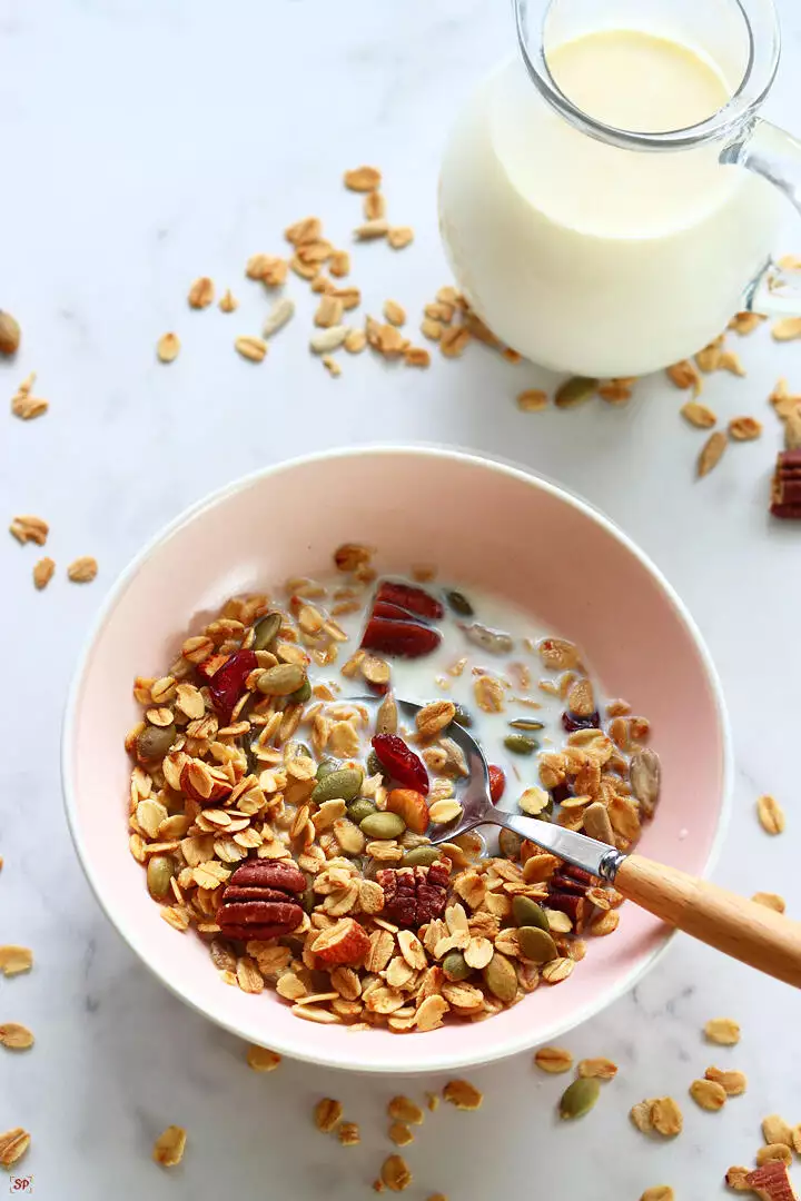 granola with milk served in a pink bowl