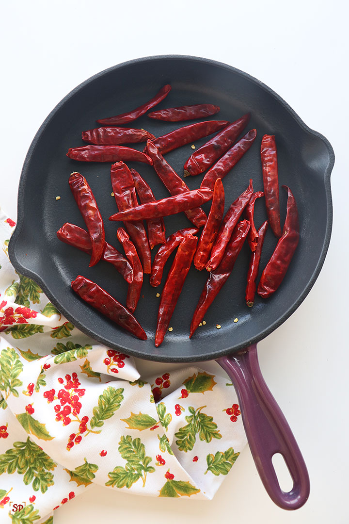 red chillies after roasting cooling down in a iron skillet