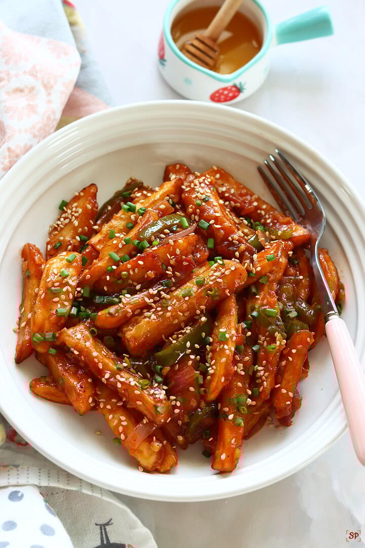 honey chilli potato served in a white rimmed plate
