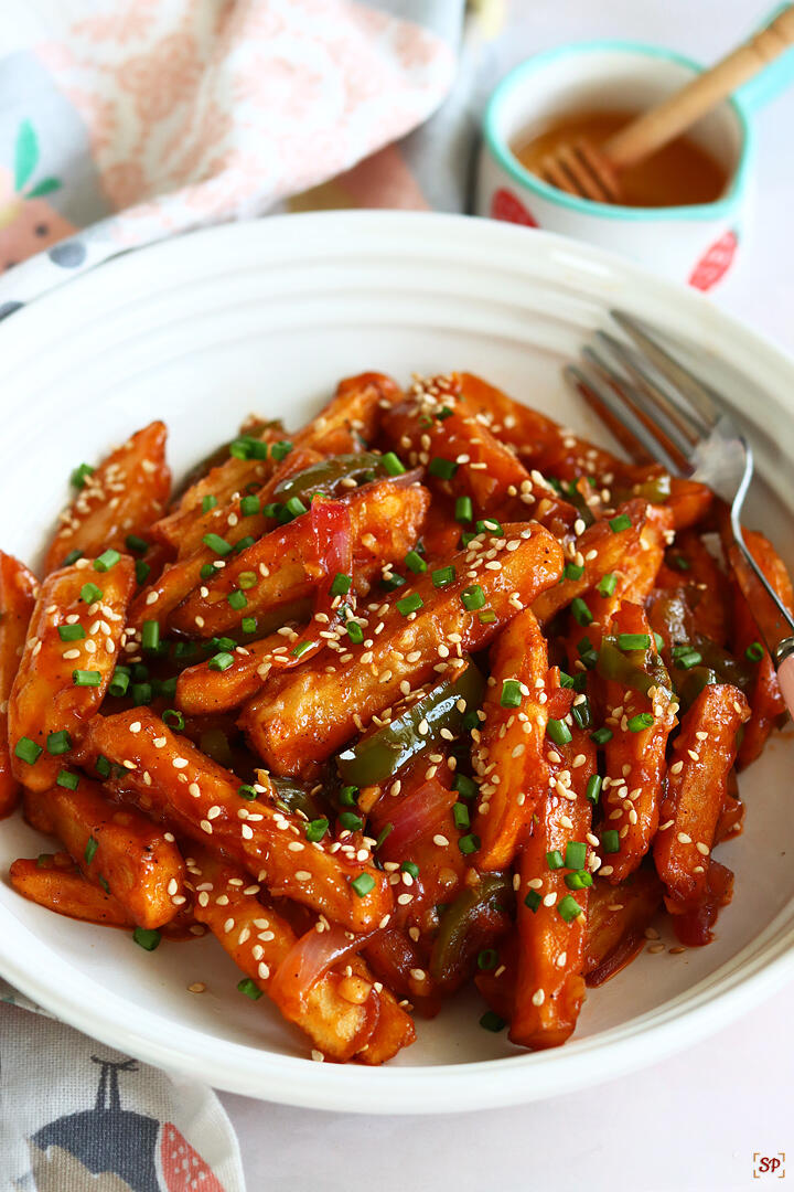 honey chilli potato served in a white rimmed plate