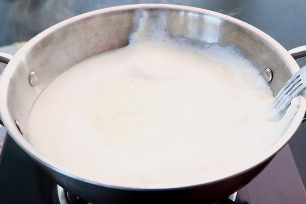 boil milk, bring malai to sides
