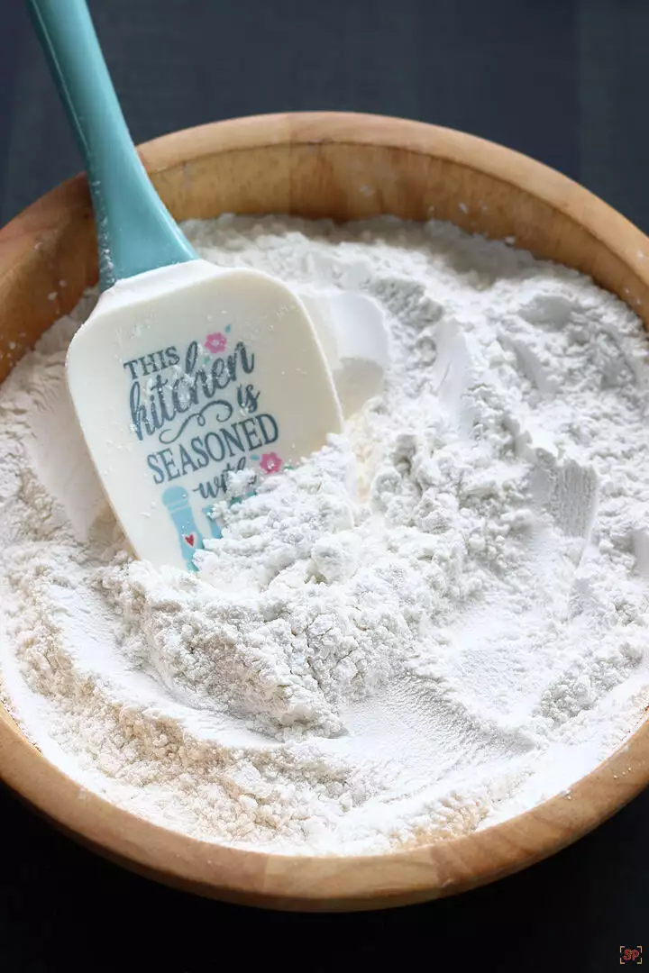 icing sugar cooling down in a wooden bowl with a spatula