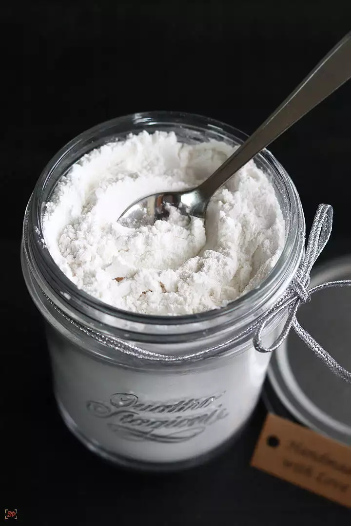 icing sugar in a glass jar with a spoon
