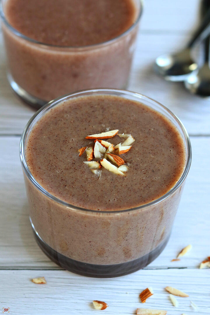 ragi malt served in a glass cup topped with almonds