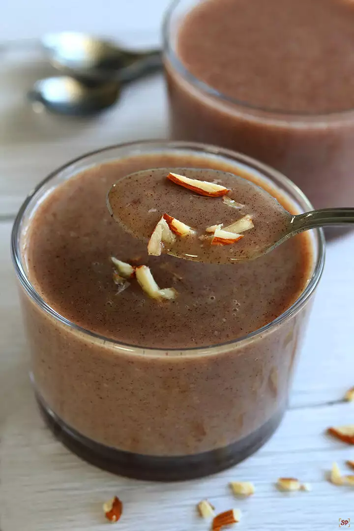 ragi malt served in a glass cup topped with almonds