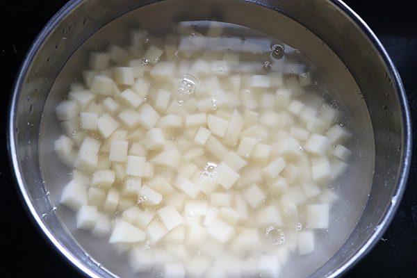 potato cubes being soaked in water