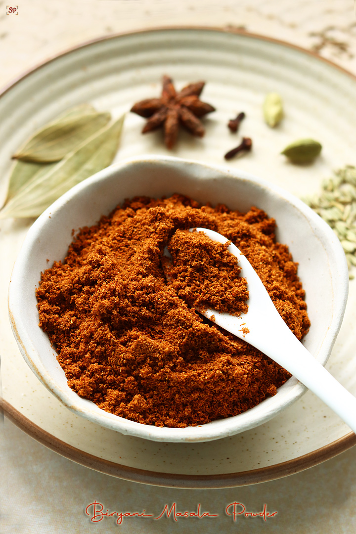 biryani masala powder placed in a bowl with whole spices on the side