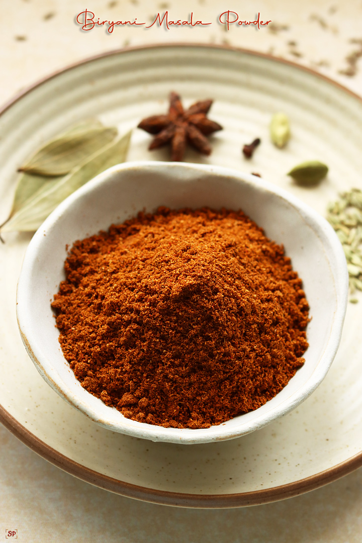 biryani masala powder placed in a bowl with whole spices on the side