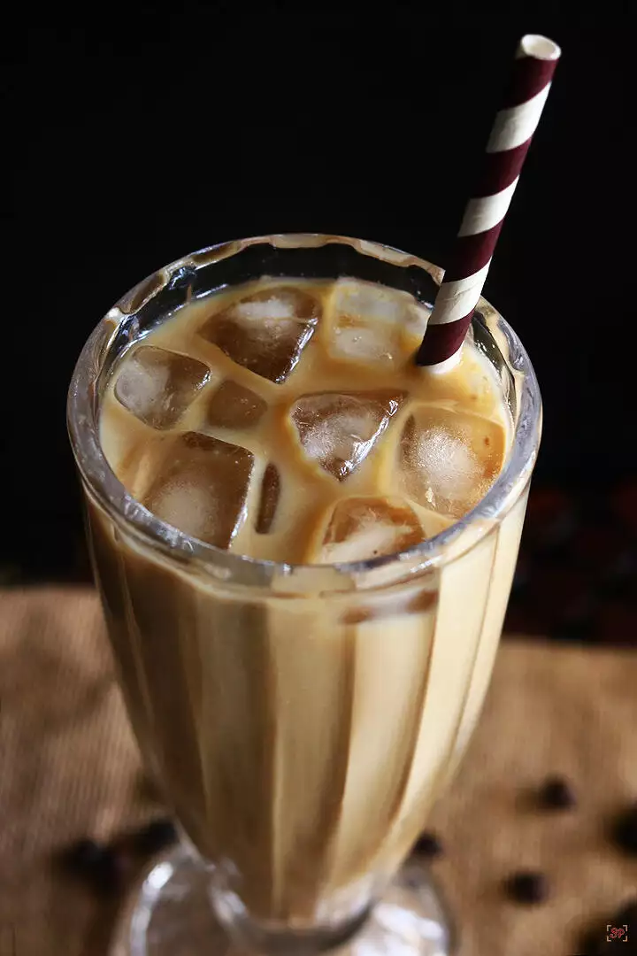 iced coffee served in a tall glass with ice cubes