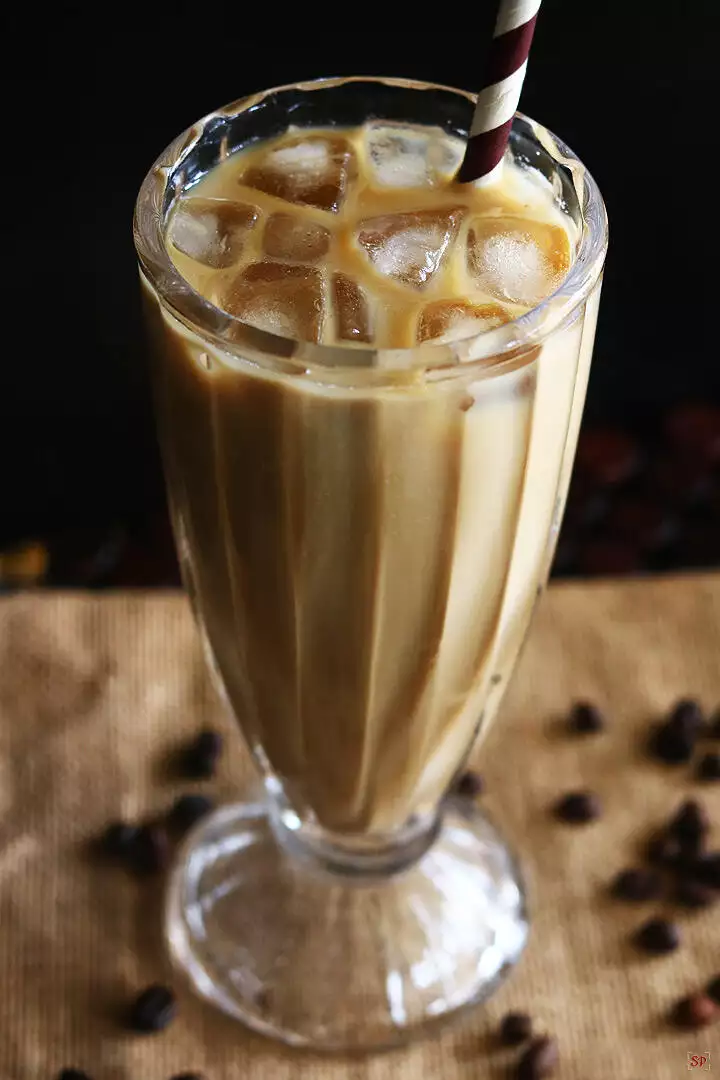 iced coffee served in a tall glass with ice cubes