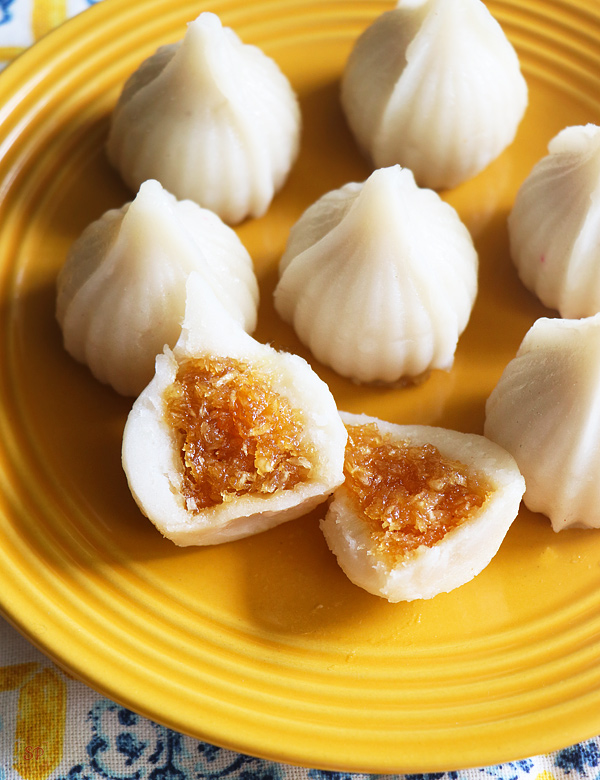 sweet dumplings with coconut filling placed in a yellow rimmed plate