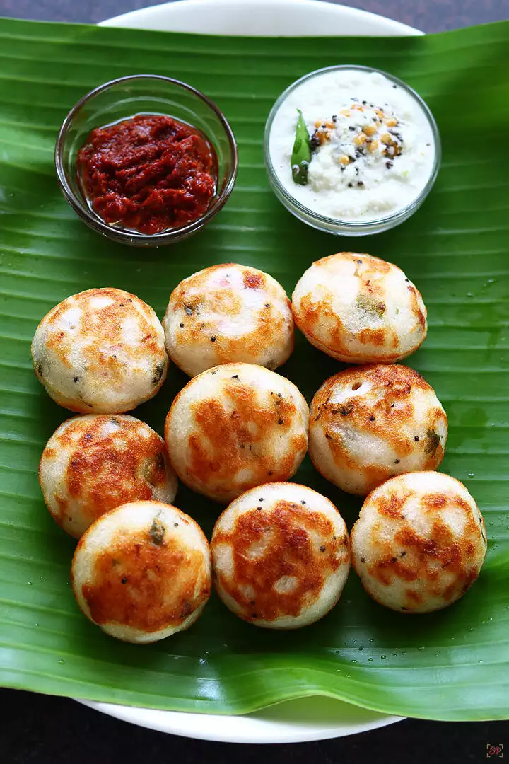 paniyaram served in banana leaf along with coconut chutney and garlic chutney