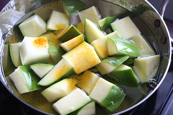 add raw mango along with salt and turmeric powder