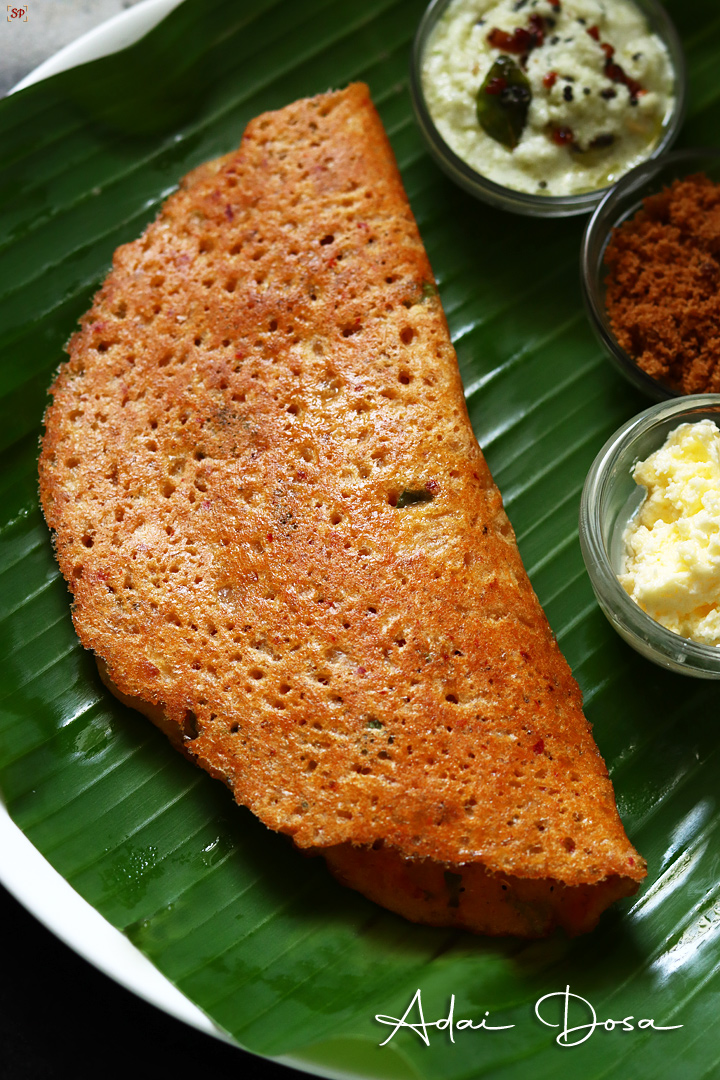 crispy adai dosa served in banana lead with butter, jaggery and coconut chutney