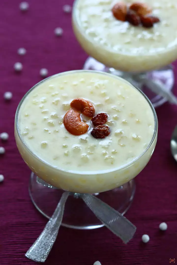 sago payasam in 2 glass bowl garnished with ghee fried cashews and nuts with spoons on the sides