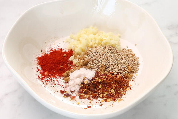 add garlic, sesame seeds, chilli powder, chilli flakes, sugar and salt