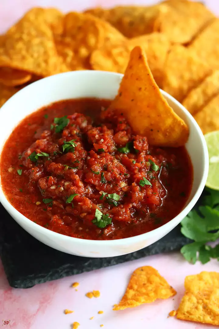 salsa served in a white bowl with tortilla chips