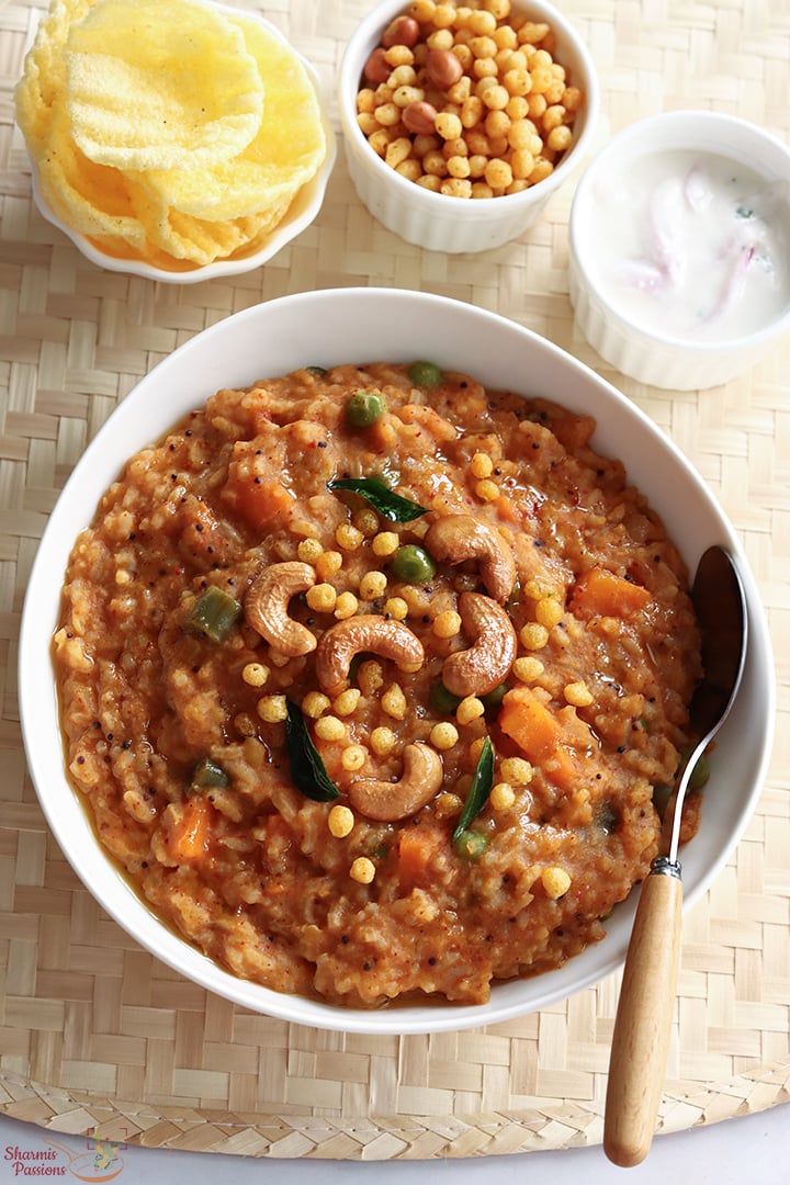 bisi bele bath serve with raita, boondi and papad