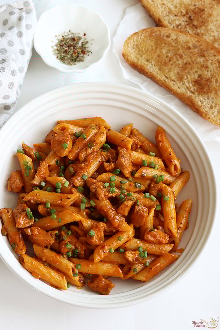 chicken pasta served with bread and mixed herbs